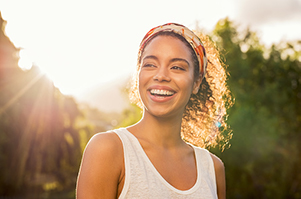 Smiling woman standing in front of sunlight