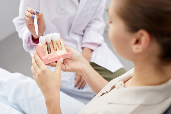 Image of a dental professional showing a patient that a dental implant is a good fit for her, at Myers Park Dental Partners.